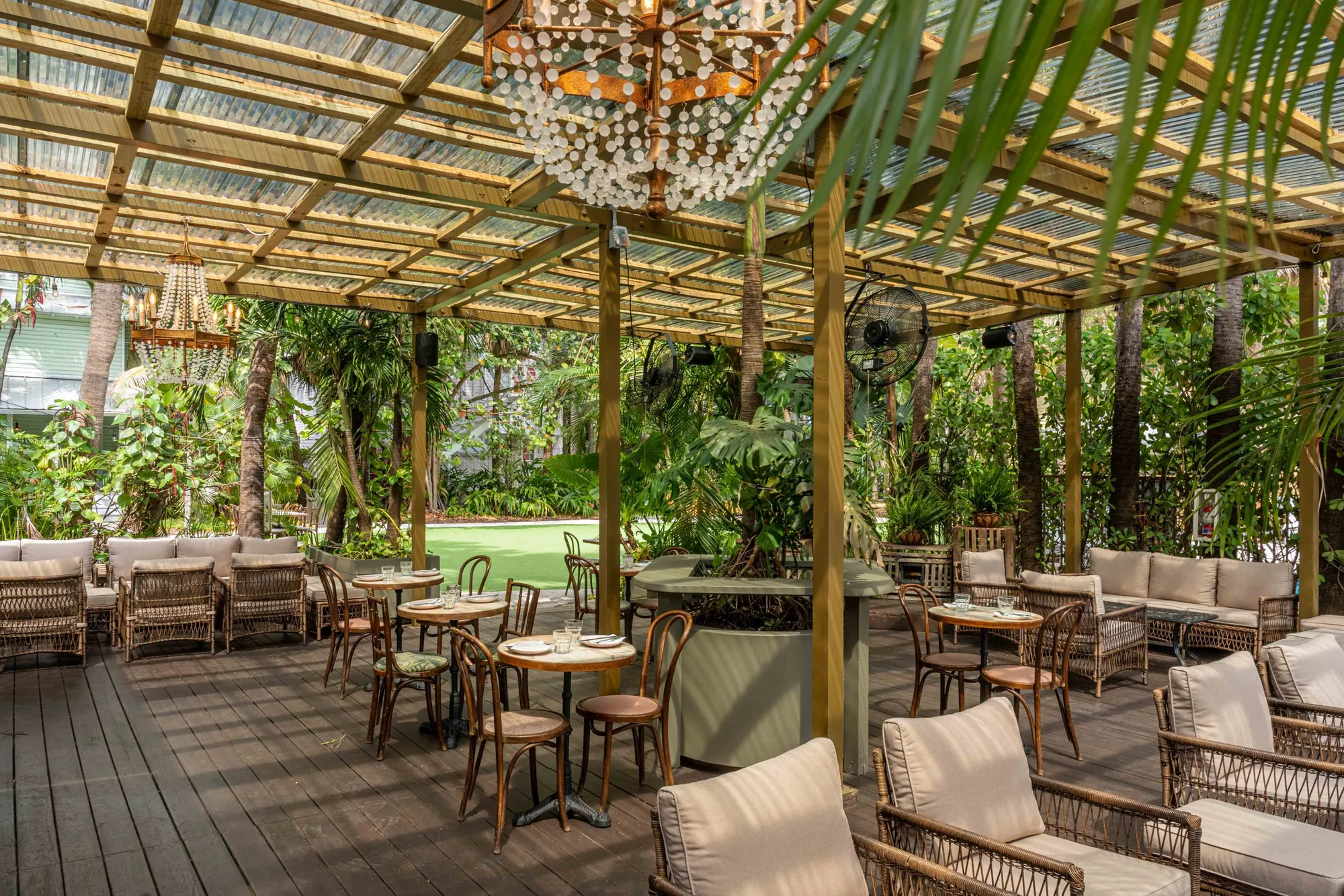 The garden dining terrace laid for dinner under the pergola