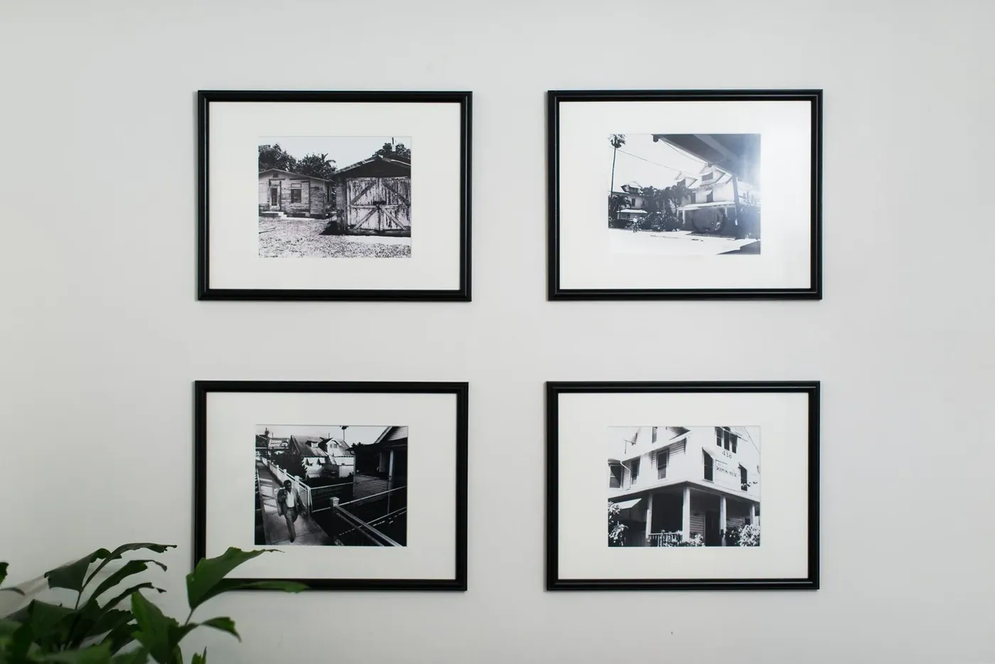 Black-and-white photographs of the houses framed on a white wall