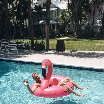 A guest floating in the pool on an inflatable flamingo