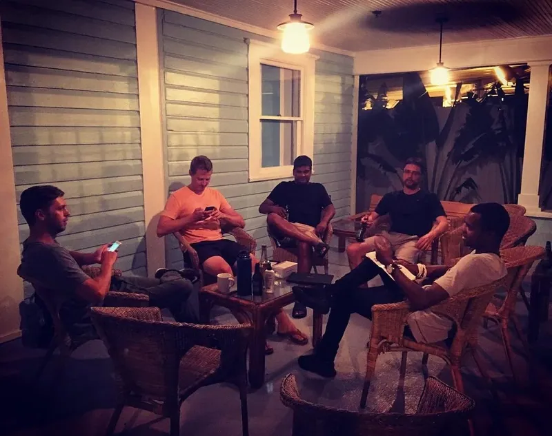 Guests talking on a lit porch after dark