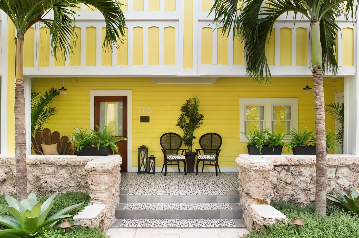 The yellow house - coral rock walls, a tiled porch and the number 118 beside the door